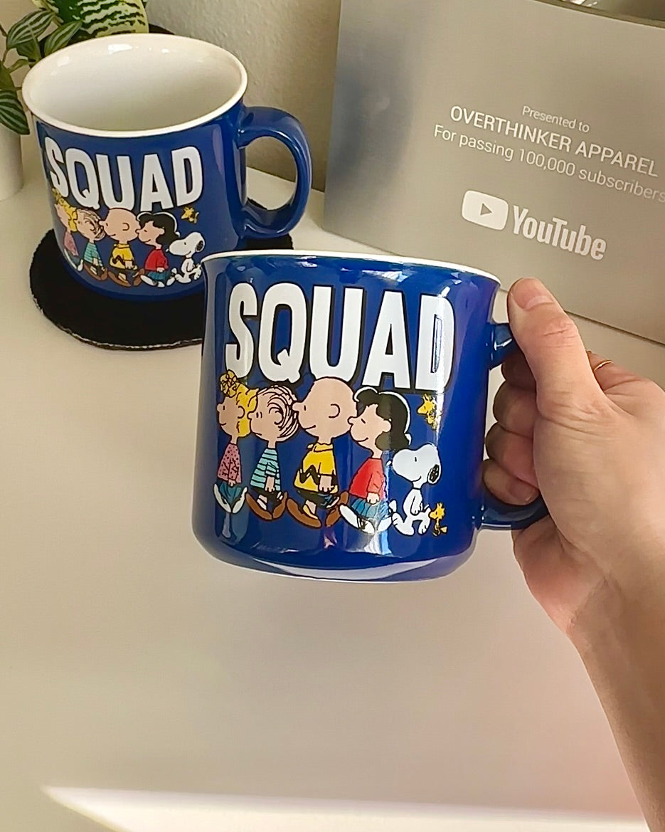 Official Peanuts “SQUAD” 20 oz camper mug in cobalt blue with wraparound Snoopy and Charlie Brown gang illustration; large ceramic friendship cup