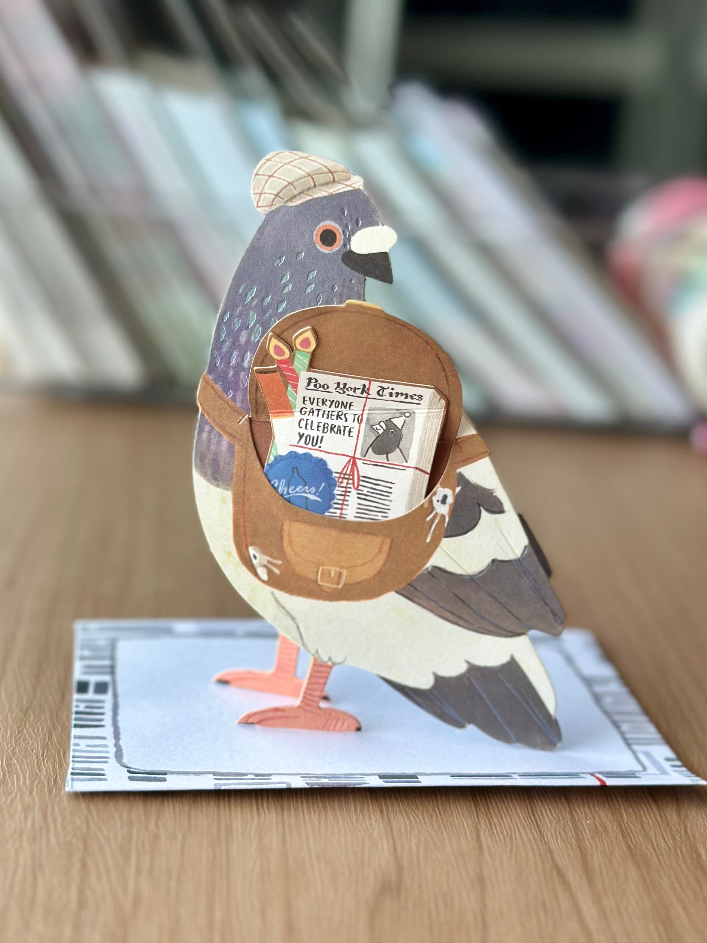 Side view of pigeon pop-up greeting card with 3D wings and messenger bag surprise.