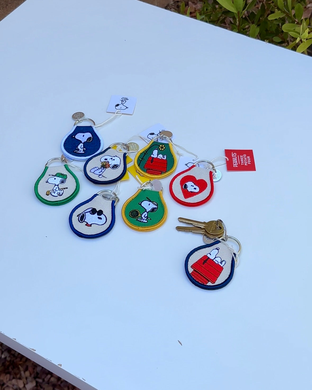 Collection of Snoopy Peanuts embroidered keychains featuring tennis Snoopy, golf Snoopy, sunglasses Snoopy, and classic Snoopy designs on a white background.