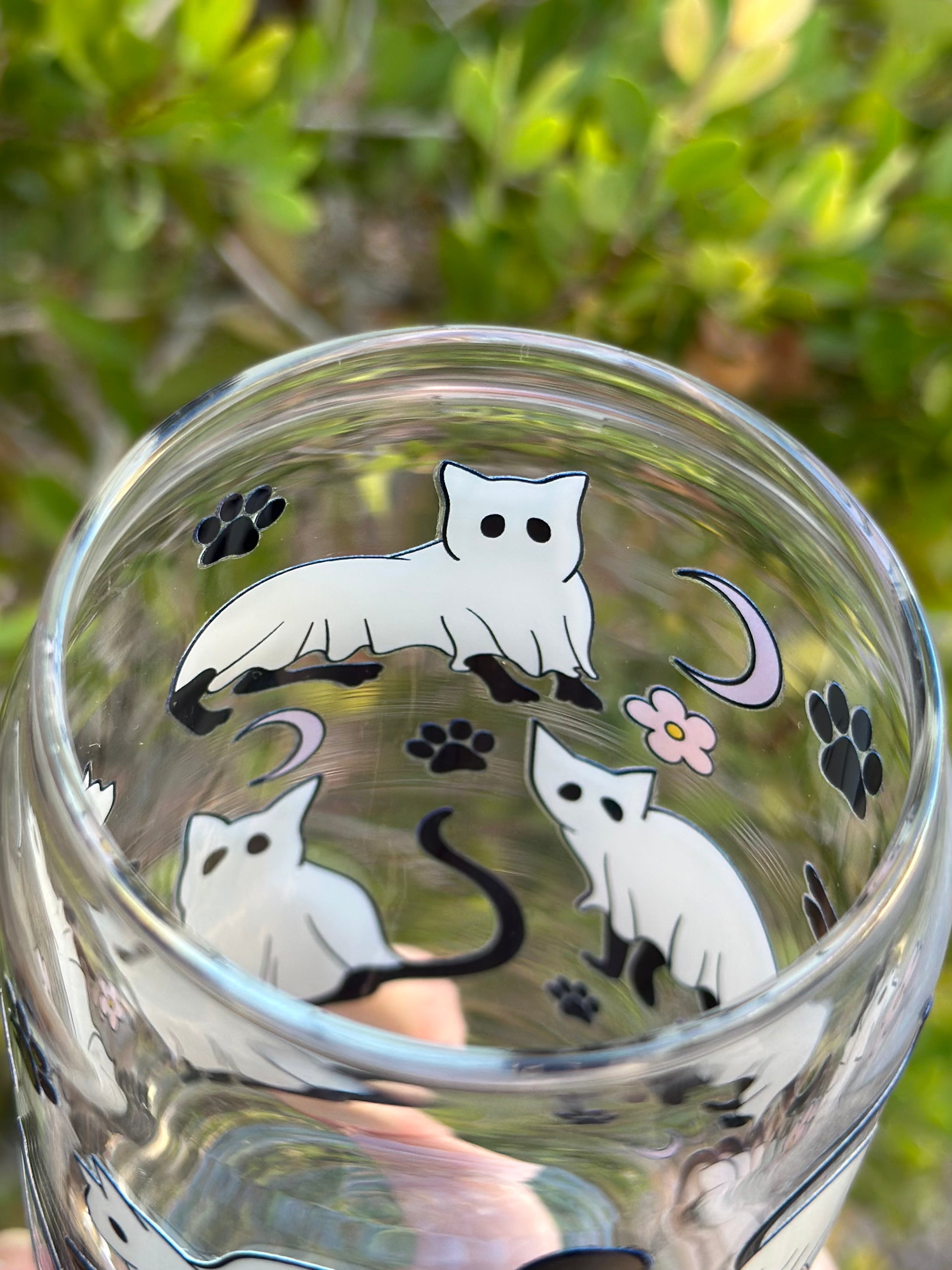 Top view of glass can cup showing black cat dressed as ghost, paw prints, moons, and flowers.