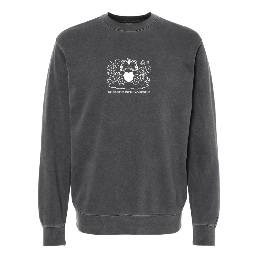 Charcoal gray crewneck sweatshirt featuring subtle white embroidery of a gentle character holding a heart with the words “Be Gentle With Yourself” on the front.