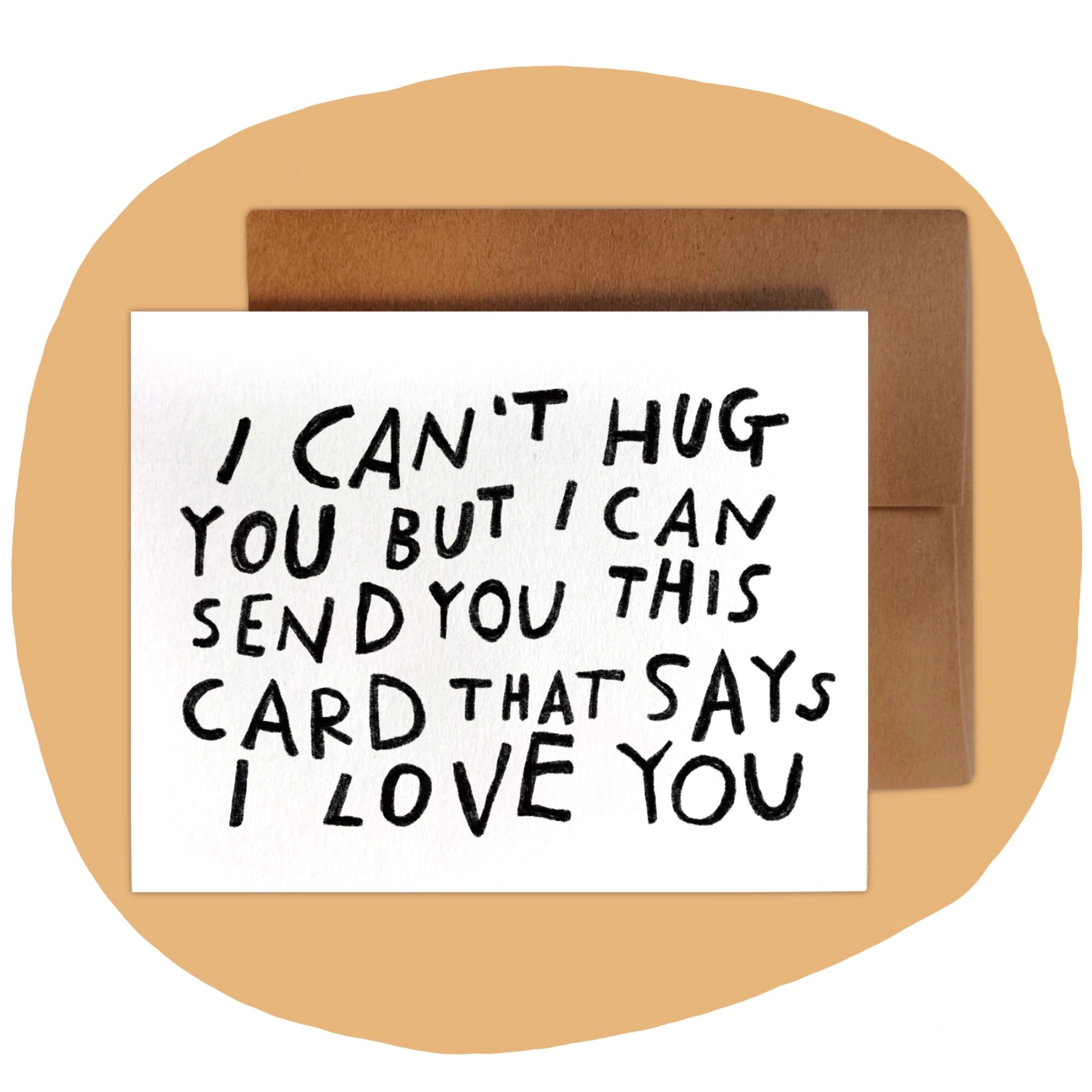 Minimalist white greeting card with black hand-lettered text that reads ‘I can’t hug you but I can send you this card that says I love you,’ paired with brown kraft envelope.