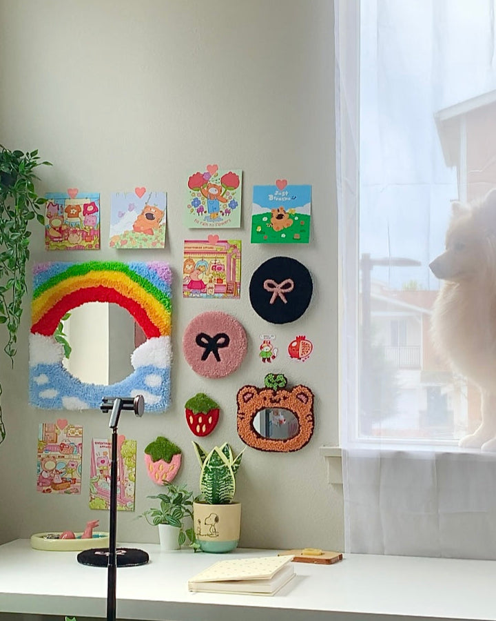 Pink and black bow rugs used as wall decor on gallery wall with cute art and plush accents