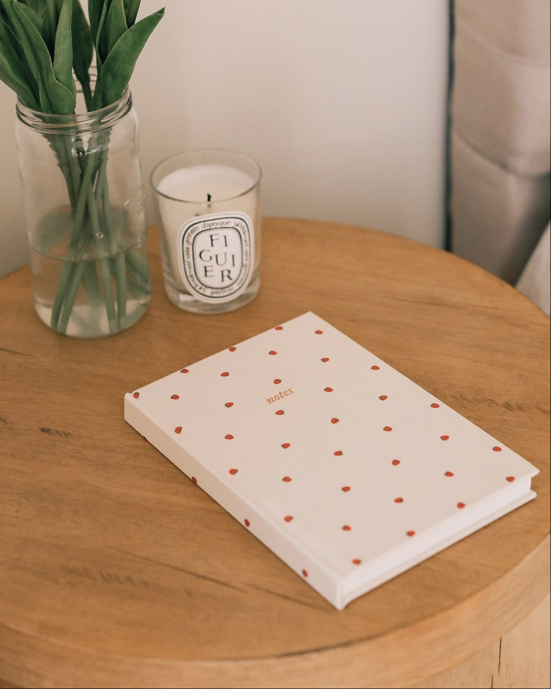 Strawberry linen A5 journal styled on a wooden table with flowers and candle, cozy aesthetic notebook for journaling and everyday notes.