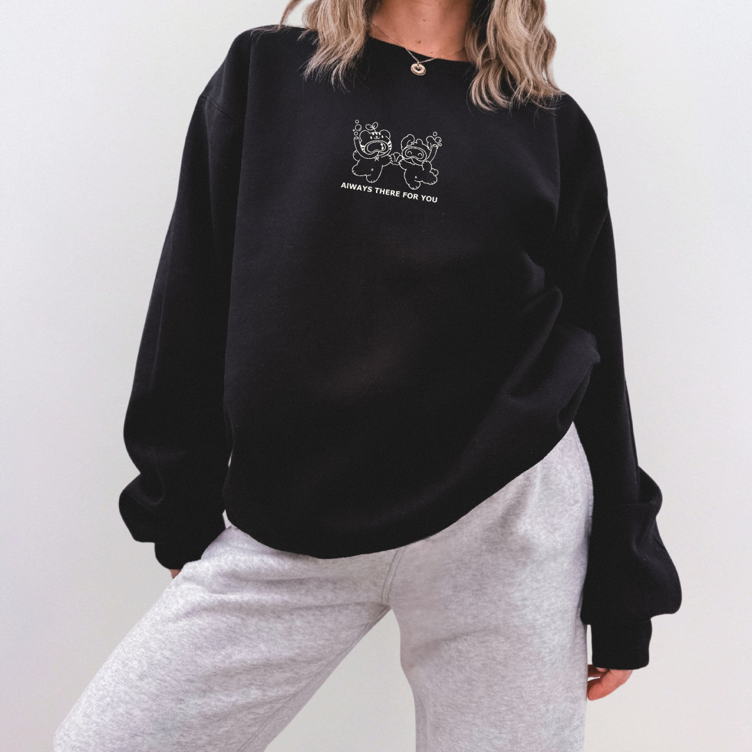 Person wearing a black sweatshirt with a white line art design of two scuba-diving bears holding hands and the text "Always There For You"