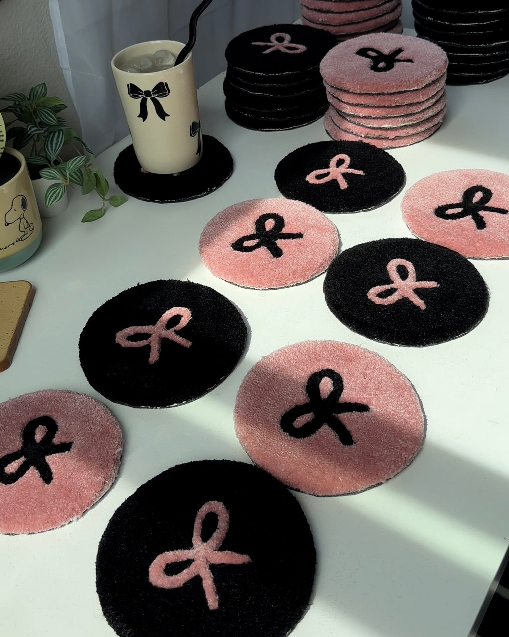 Pink and black bow rugs used as wall decor on gallery wall with cute art and plush accents