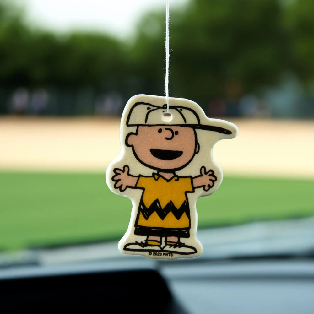 Charlie Brown air freshener hanging from a car mirror. Morning Mist scent with cheerful Peanuts design. Cute and nostalgic car accessory.