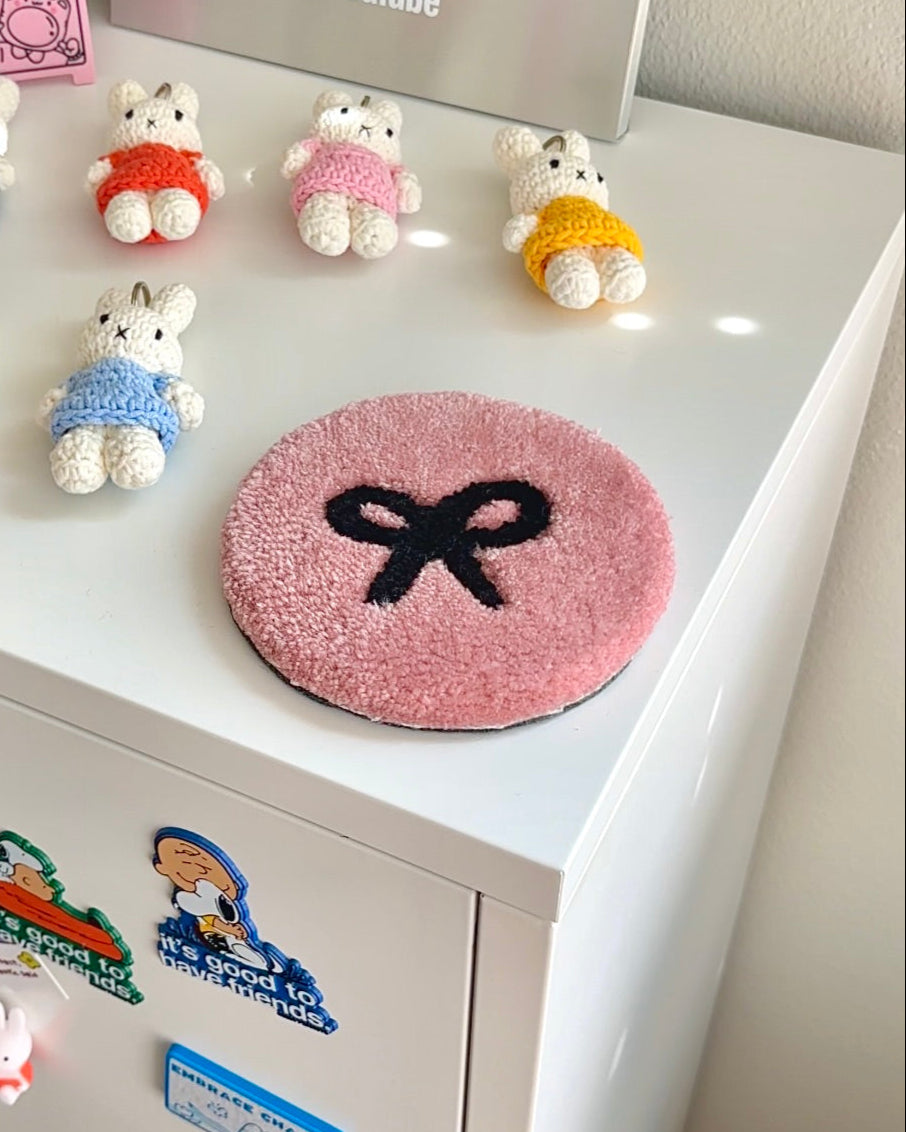 Pink bow tufted coaster styled with crochet Miffy plushies on shelf