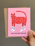 Western-themed cat birthday card with red spotted cat wearing white cowboy boots on pink background, captioned ‘Happy Birthday Partner!’ with brown kraft envelope.