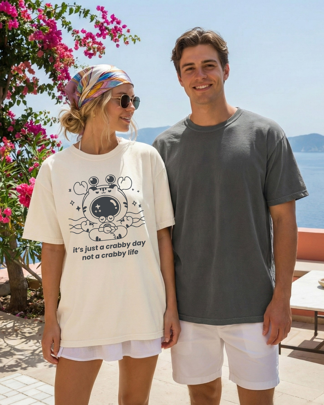 Two people wearing casual t-shirts outdoors, including an ivory graphic tee with a meditating crab and the phrase “it’s just a crabby day not a crabby life”