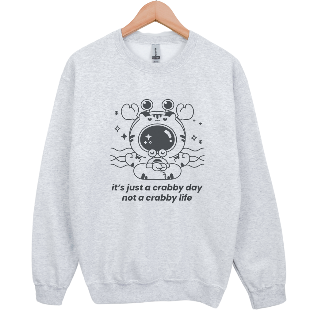 Flat lay of gray crewneck sweatshirt with crab and tiger illustration and mental health quote – coastal-core comfort sweatshirt for hard days