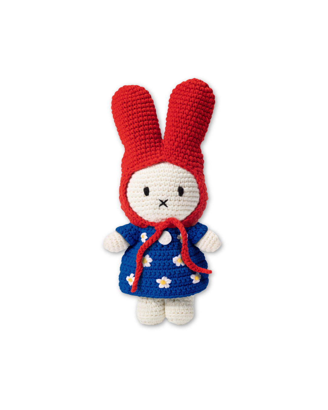 Handmade crochet Miffy plush wearing a red bonnet and blue floral dress isolated on background, cute amigurumi bunny stuffed animal