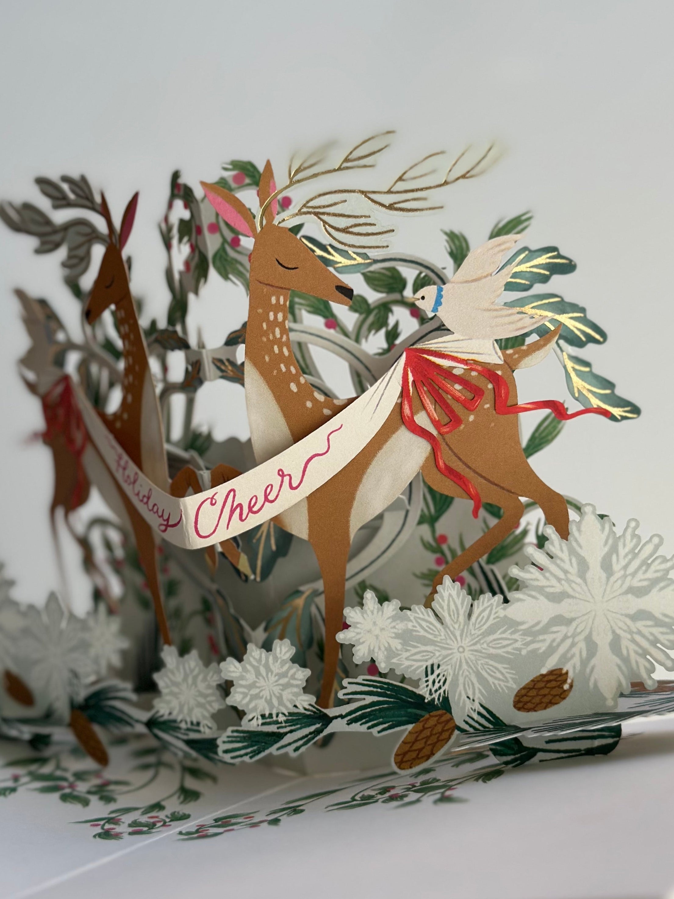 Pop-up holiday card close-up of deer with banner reading “Holiday Cheer.”