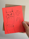 Funny red cat birthday card with hand-drawn unimpressed cat crossing arms, captioned ‘Your birthday was last year’ with brown kraft envelope.