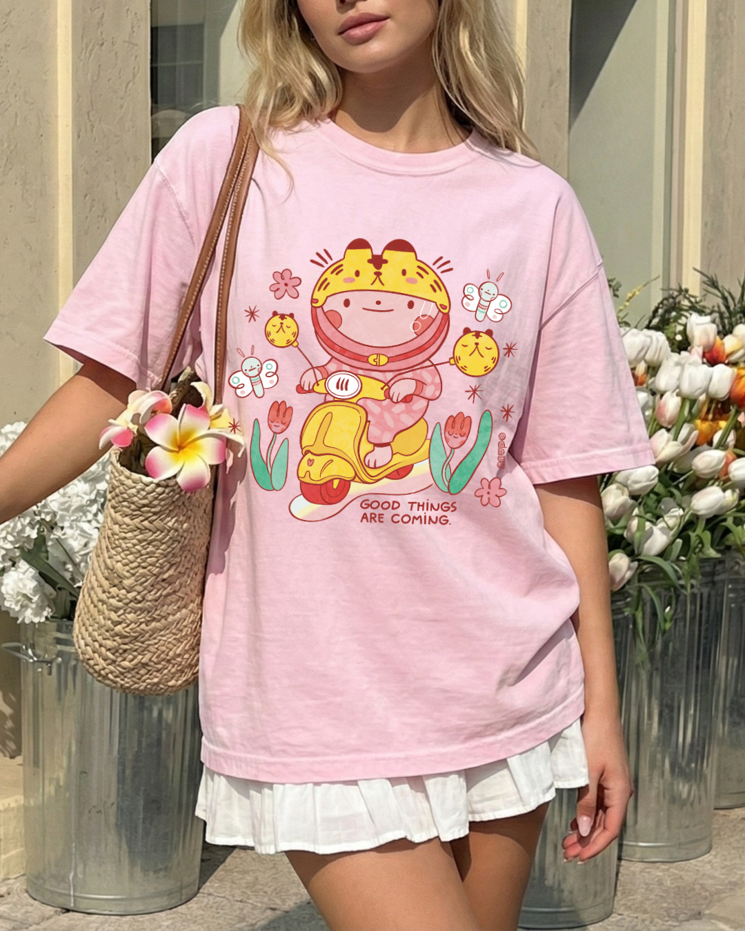 Soft pink graphic t shirt with cute illustration and the phrase good things are coming worn casually outdoors