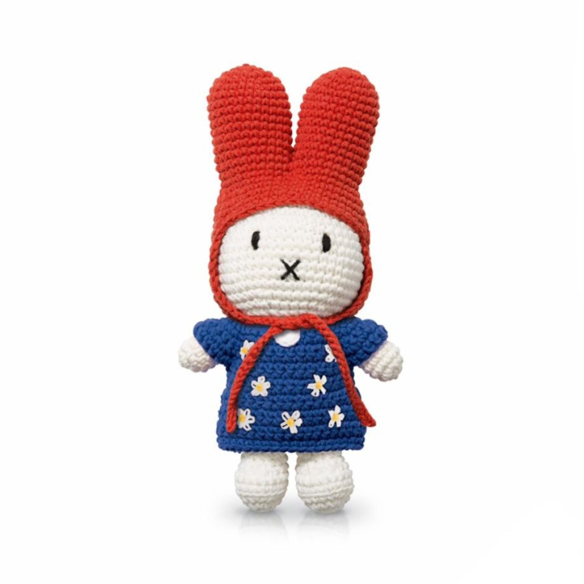 Zoomed-in view of a crochet bunny doll in a red bonnet and blue dress with white and yellow daisy embroidery — charming, flower-themed soft toy.