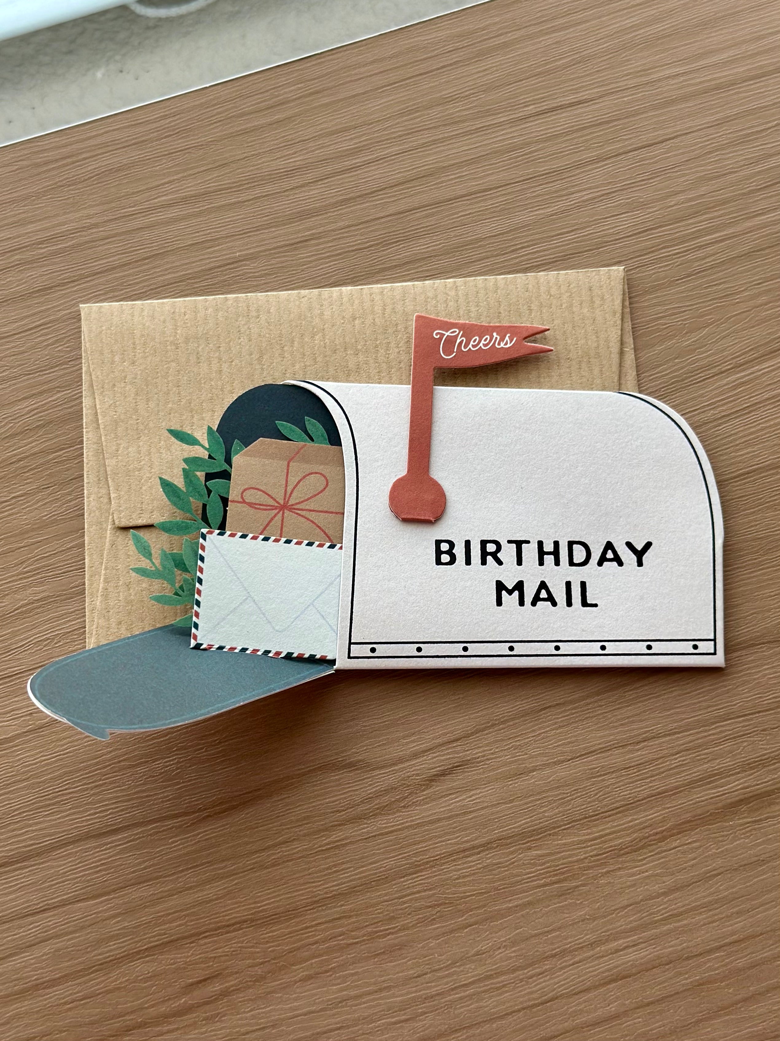 Birthday mailbox pop-up card opened to reveal letters, greenery, and birthday gifts inside.
