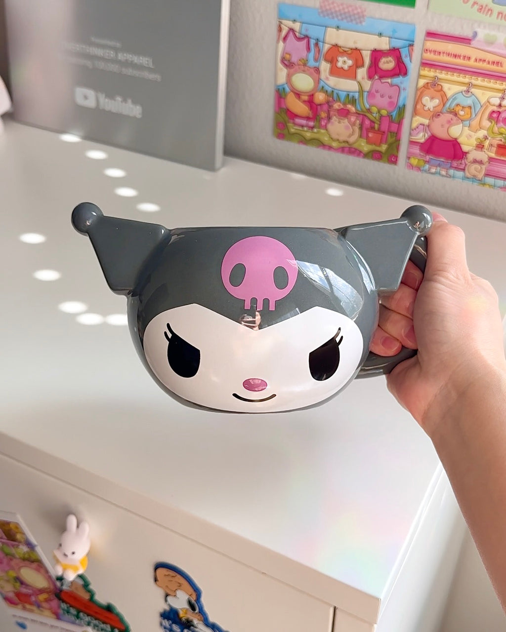 Kuromi 3D sculpted ceramic mug with gray finish, pink skull detail, and signature smirk, officially licensed Sanrio mug held in hand, oversized 20 oz capacity.