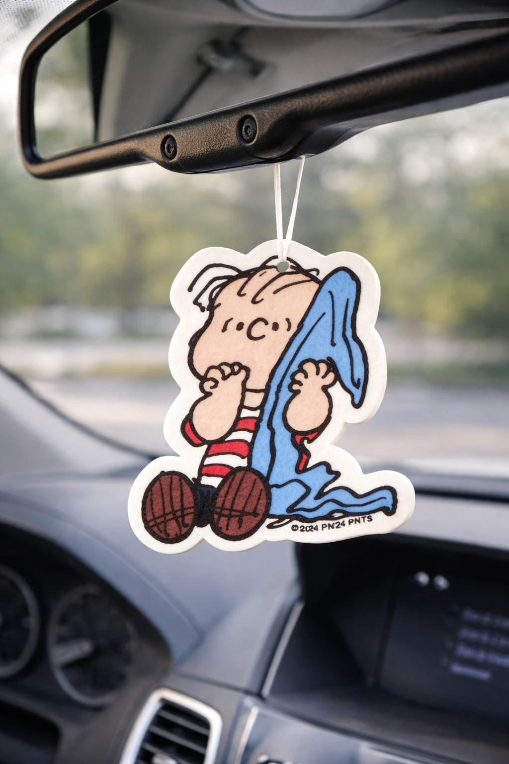 Linus Peanuts car air freshener hanging from rearview mirror, nostalgic cartoon car accessory for cute car decor.