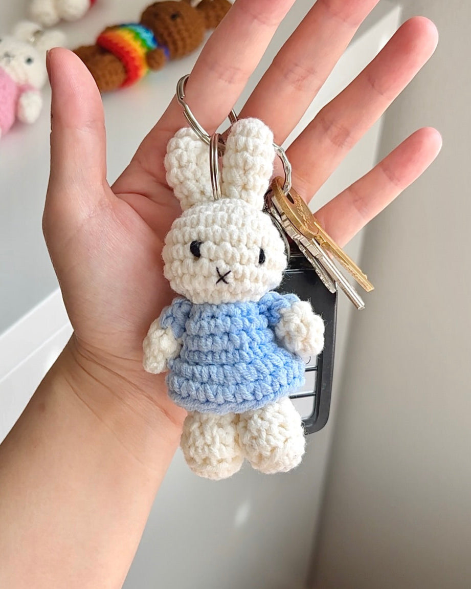 Miffy crochet keychain in baby blue dress, held in hand with keys