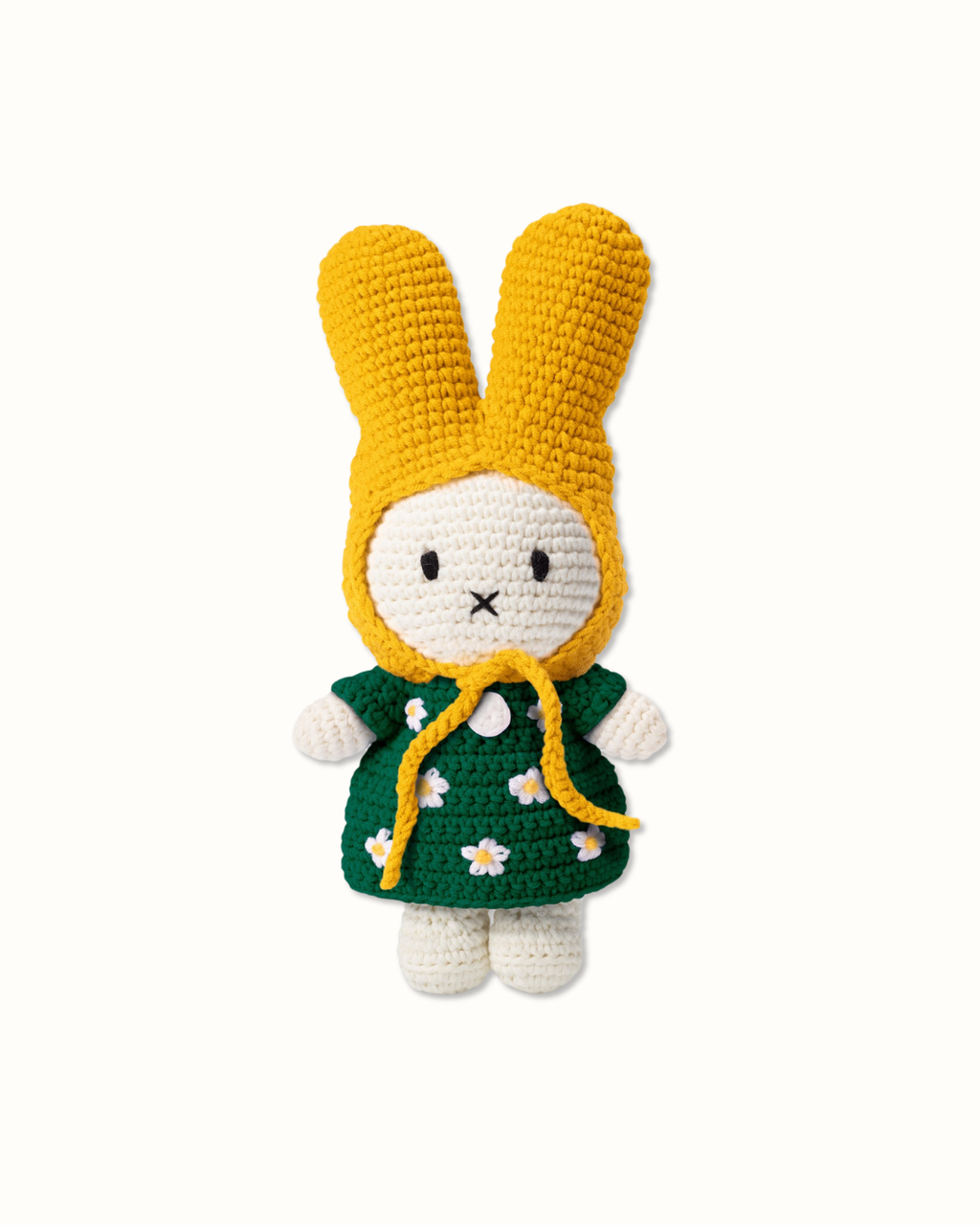 Miffy crochet plush toy with yellow bonnet and green daisy dress isolated on white background, handmade amigurumi bunny plush