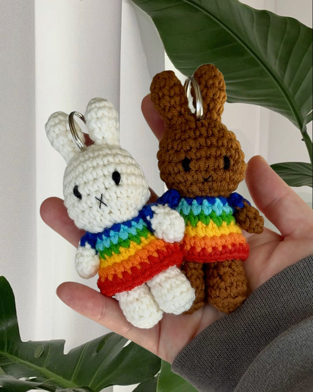 Miffy crochet keychains in rainbow dresses shown together, handmade cotton bag charms with soft texture and metal keyrings.