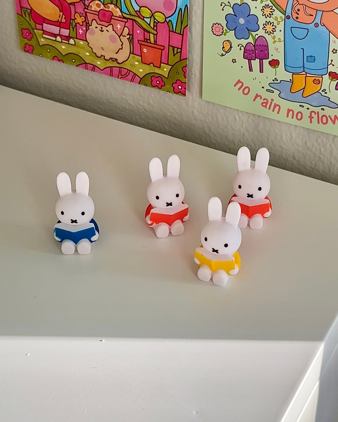 Set of four Miffy reading magnets in red, blue, yellow, and orange arranged together on a desk surface
