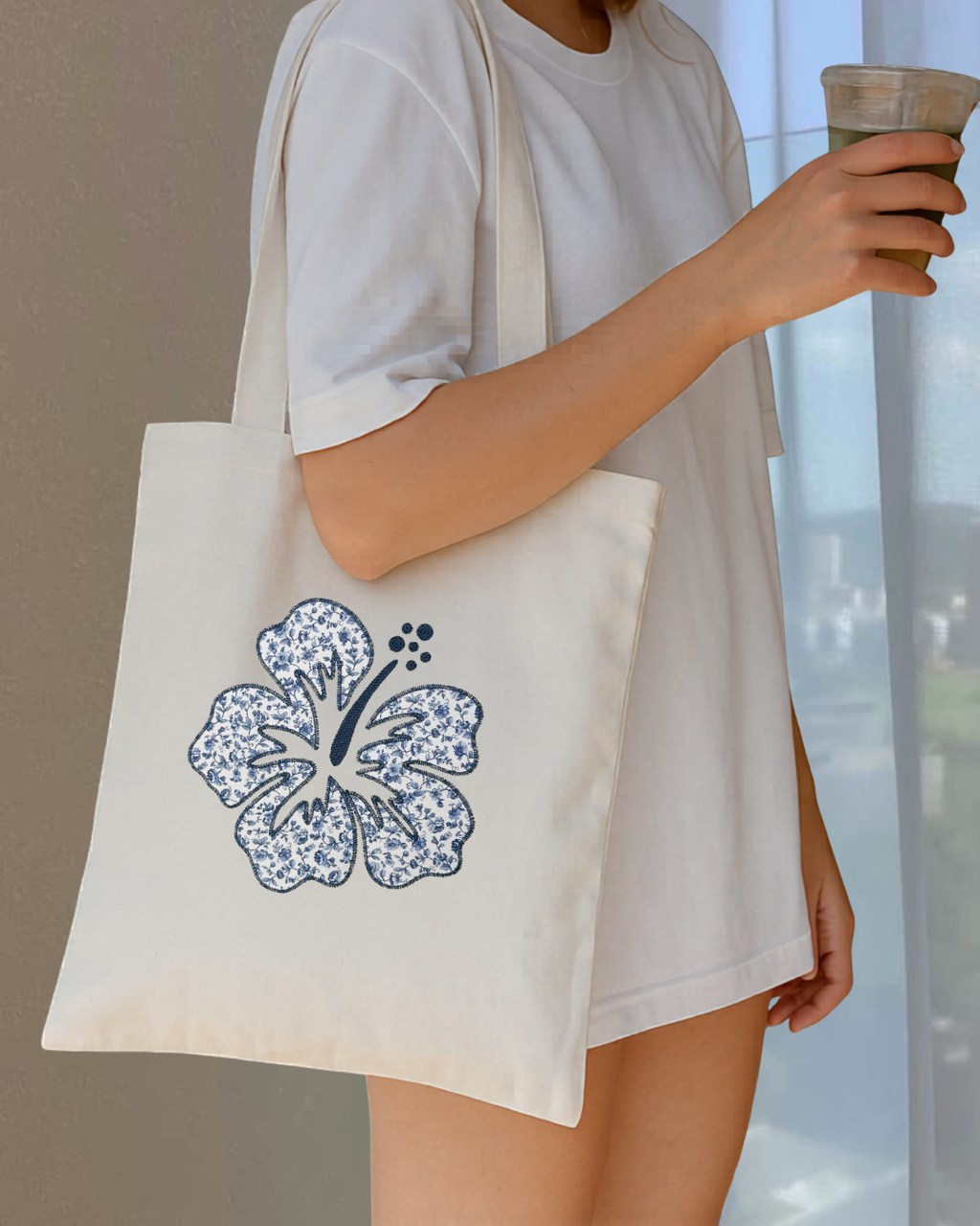 Navy hibiscus embroidered canvas tote bag worn with casual outfit, aesthetic coastal everyday floral tote