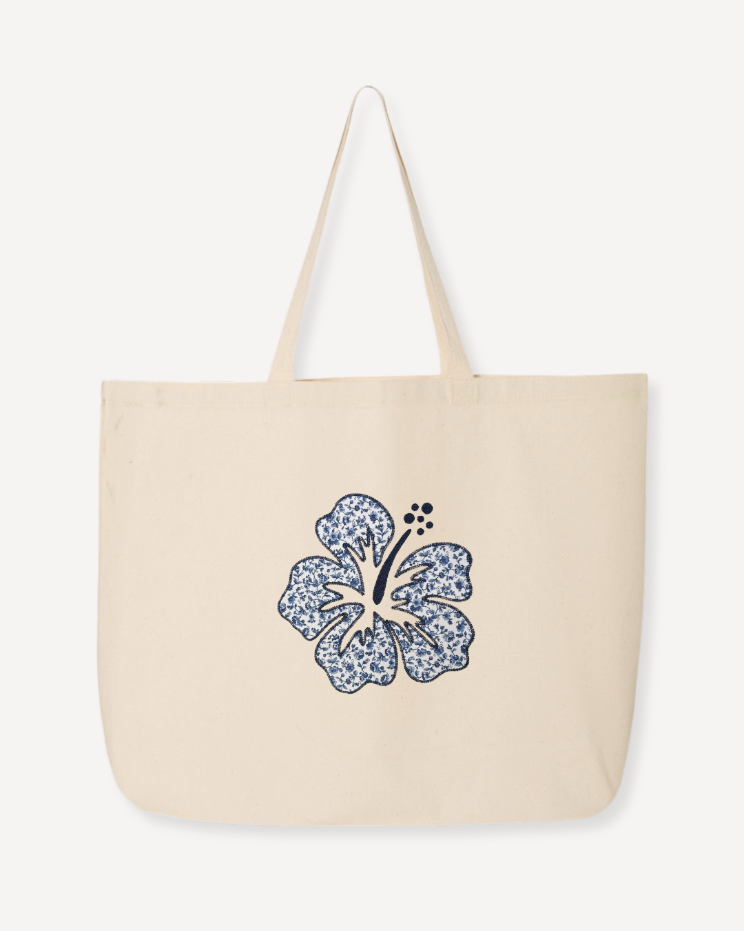 Oversized natural canvas tote bag with navy hibiscus embroidery and bottom gusset, large floral tote for travel, beach, or daily carry