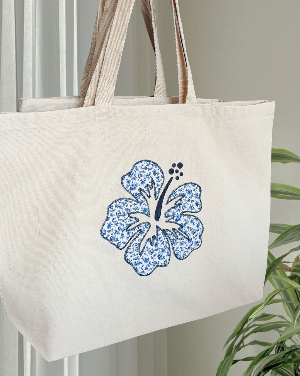 Oversized natural canvas tote with navy hibiscus embroidery and bottom gusset, large floral tote bag for travel or daily carry