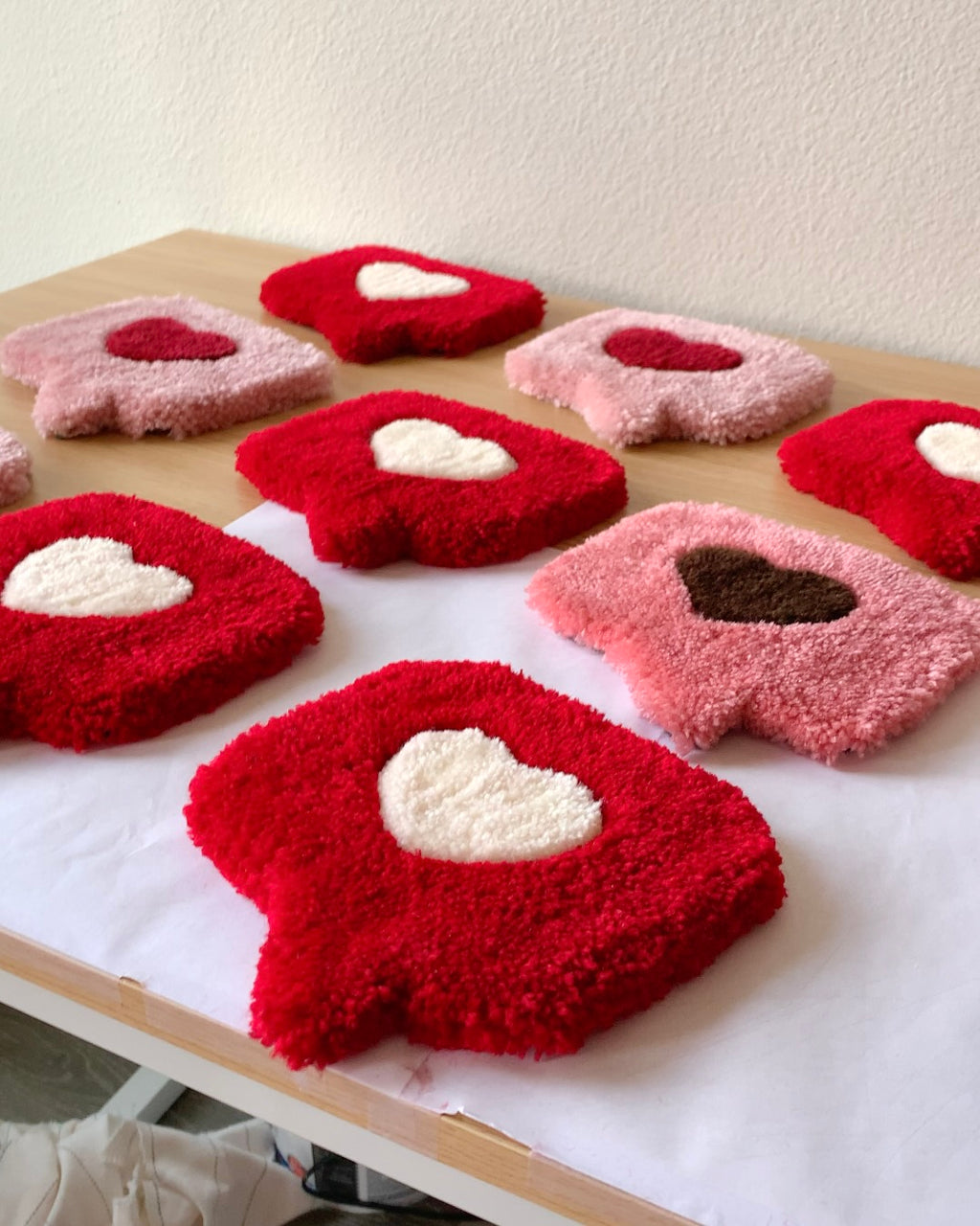 Close-up of a plush tufted heart mug rug with raised heart design, soft handmade coaster used as a mug rug or jewelry mat.