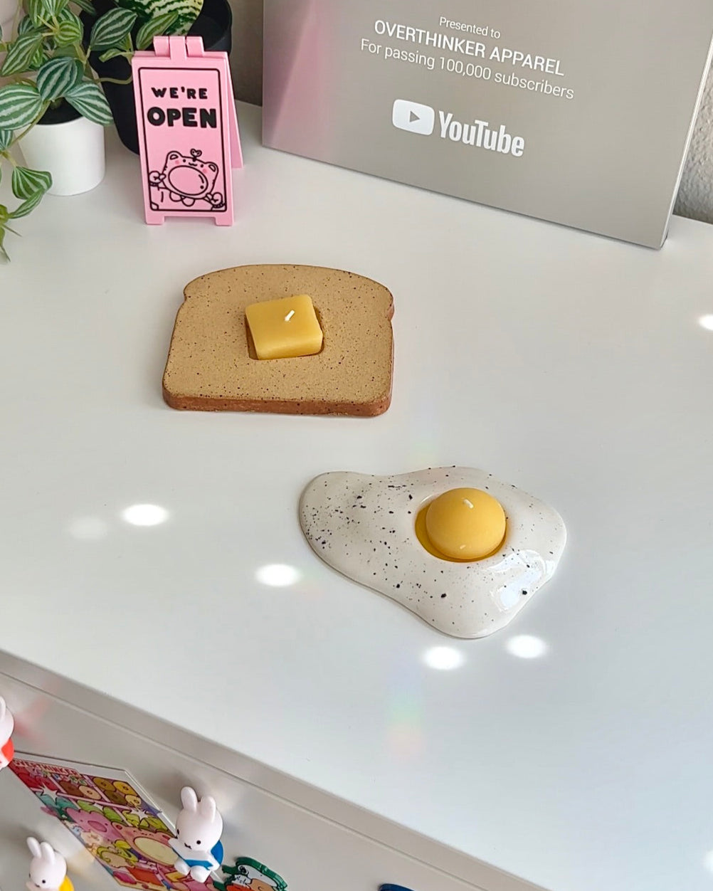 Toast and egg candle set styled on a white desk with cute decor