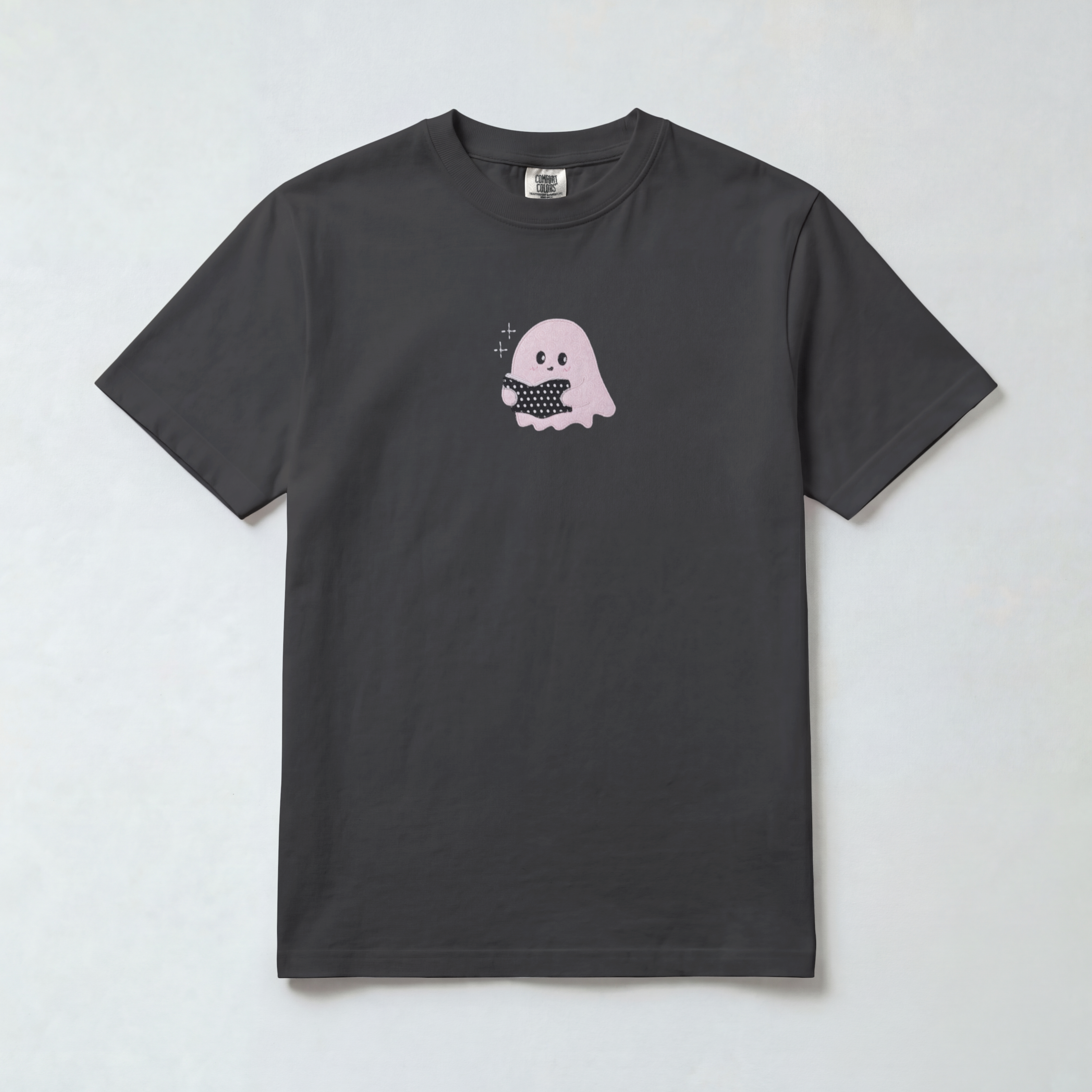 A dark charcoal gray short-sleeve t-shirt with a small graphic of a cute pink ghost holding a black-and-white checkered square on the chest, displayed flat against a light gray background.