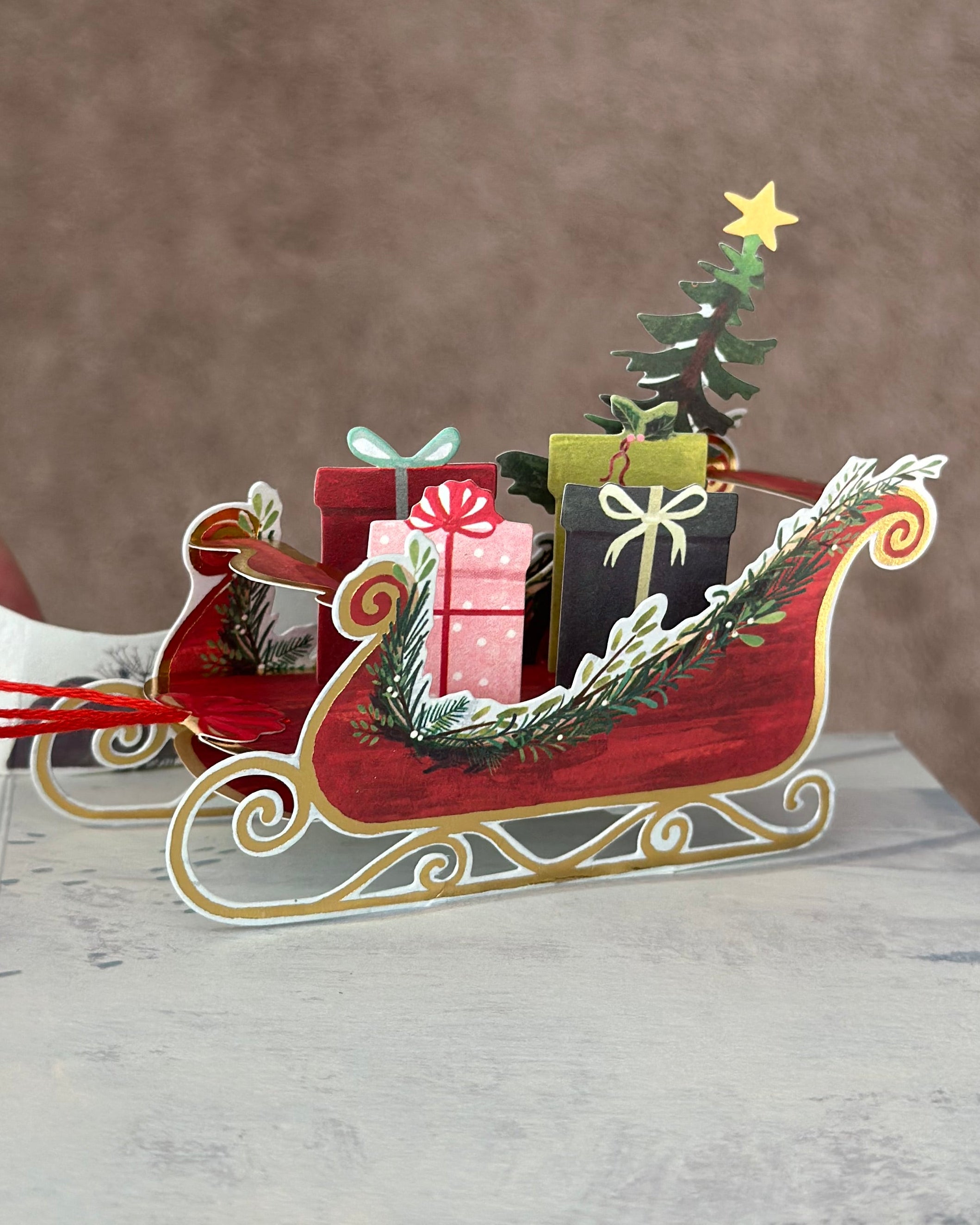 Red sleigh with presents and mini Christmas tree from a pop-up Christmas card.