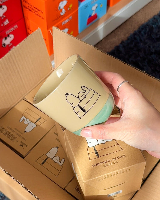 Official Snoopy “Dog Tired” stoneware mug with minimalist line-art and reactive glaze, packaged in a kraft Peanuts® gift box
