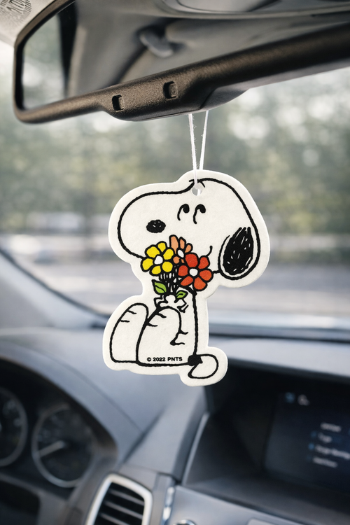 Snoopy holding flowers car air freshener hanging from rearview mirror, cute aesthetic car decor for Snoopy lovers.