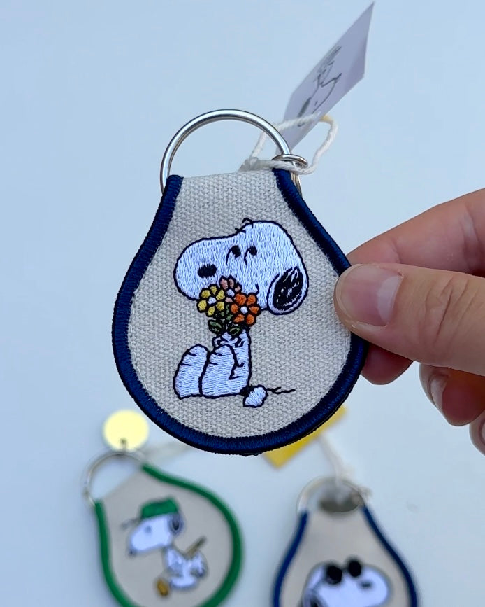 Embroidered Snoopy flower keychain on a white background, part of the Peanuts® patch keychain series.