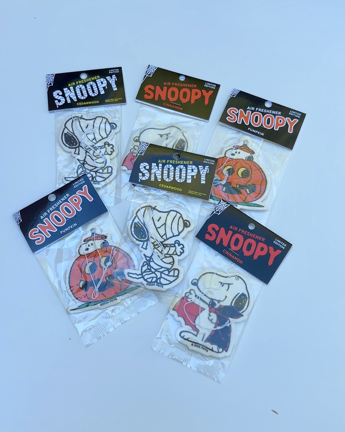 Limited edition Snoopy Halloween air fresheners featuring Peanuts® characters in pumpkin, vampire, and mummy costumes. Includes cedarwood, cinnamon, and pumpkin scents. Official Peanuts® collectible – perfect for spooky season gifts and car decor.