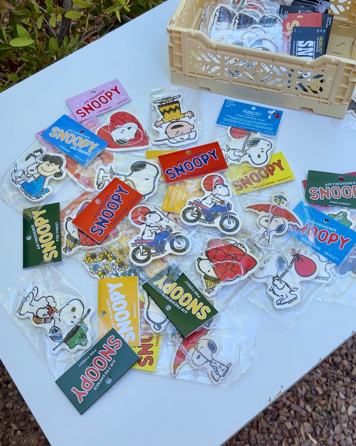 Flat lay of assorted Snoopy and Charlie Brown air fresheners, featuring Snoopy Motorcycle sandalwood scent in the center.
