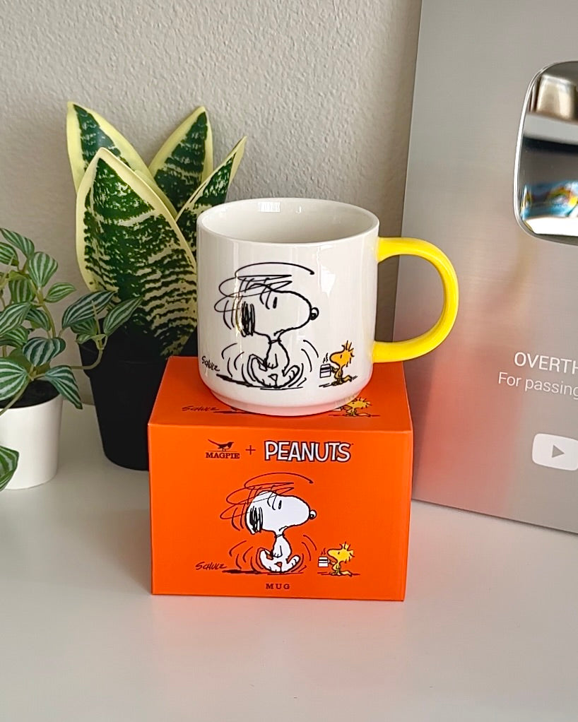 Snoopy mug on top of matching orange Peanuts box for display