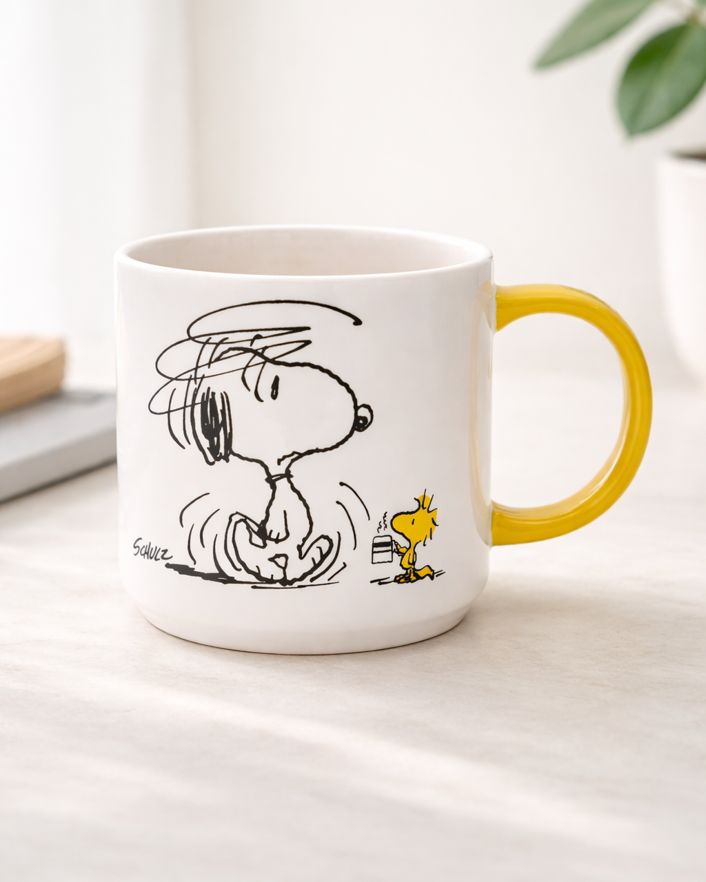Snoopy Not Worth a Thing Before Coffee Peanuts ceramic mug with yellow handle on a neutral desk, funny coffee mug for cozy mornings and Snoopy fans