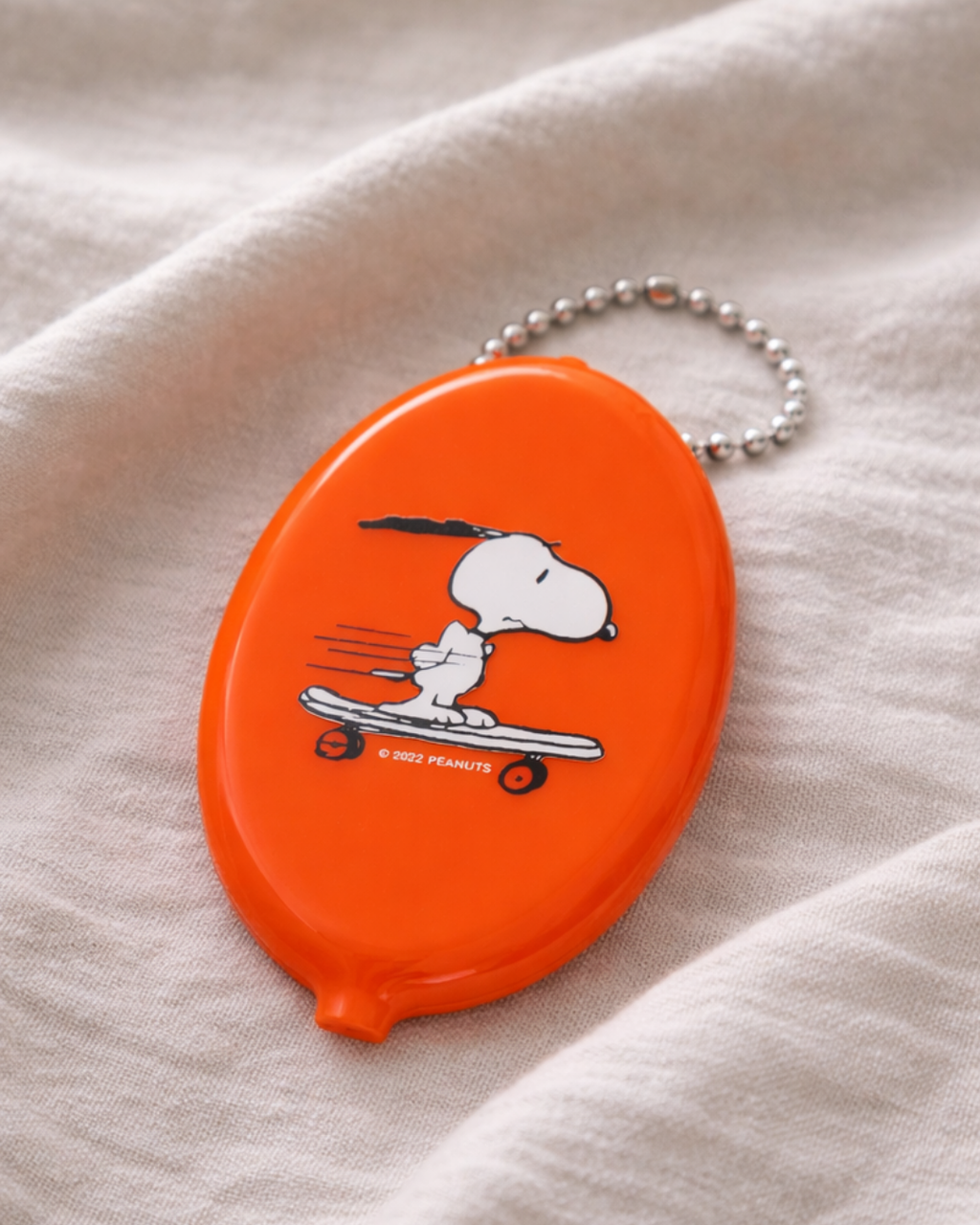 Orange Snoopy skateboard coin pouch keychain inspired by Peanuts cartoon, small vinyl coin purse keychain for change, cute Snoopy bag accessory collectible