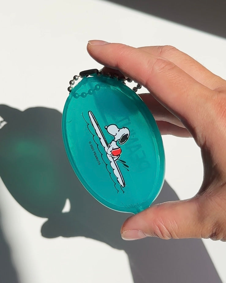 Turquoise Snoopy surf coin pouch keychain held in hand with ball chain.