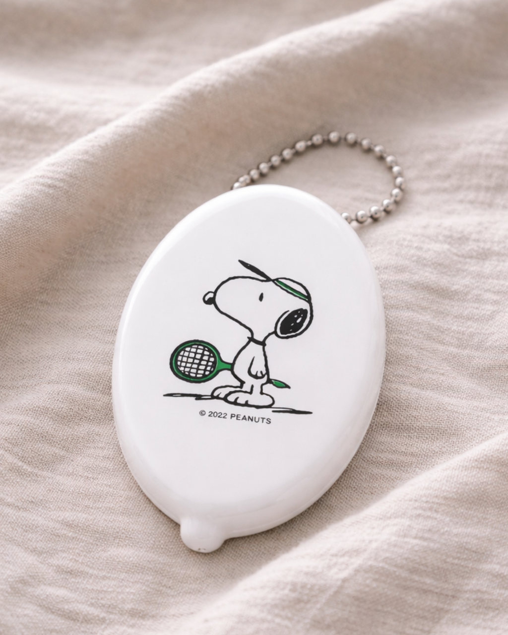 White Snoopy tennis coin pouch keychain inspired by Peanuts cartoon, small vinyl coin holder purse for loose change, Snoopy fan accessory bag charm