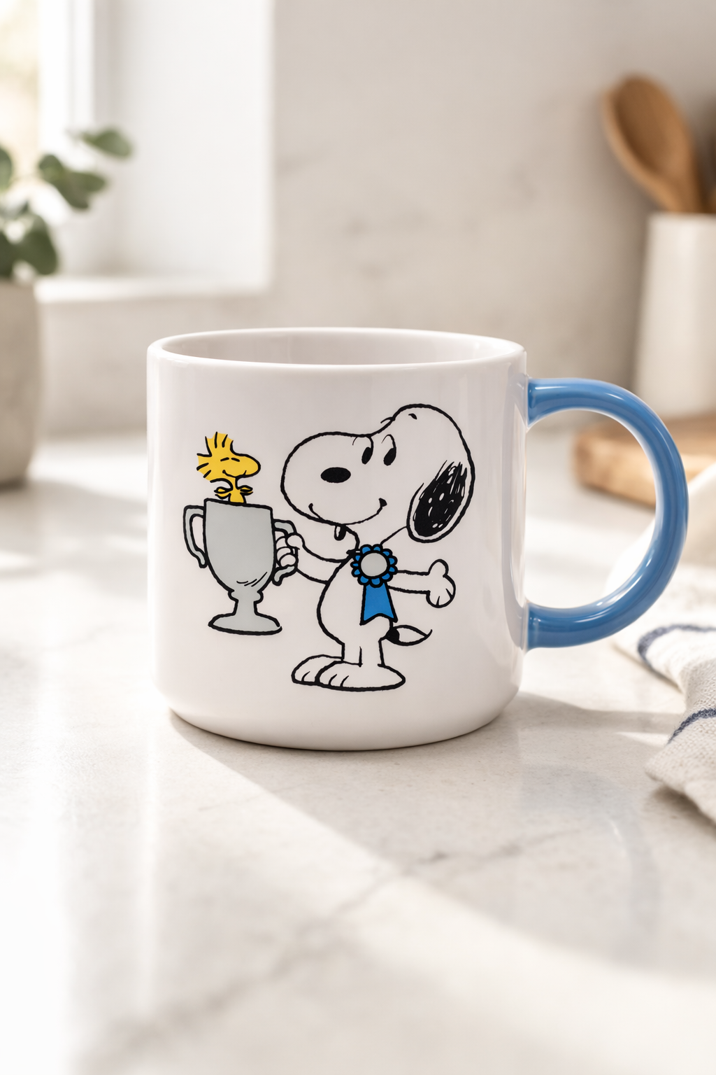 Snoopy Top Dog ceramic coffee mug with blue handle on a bright kitchen counter, cute Peanuts mug for cozy morning coffee