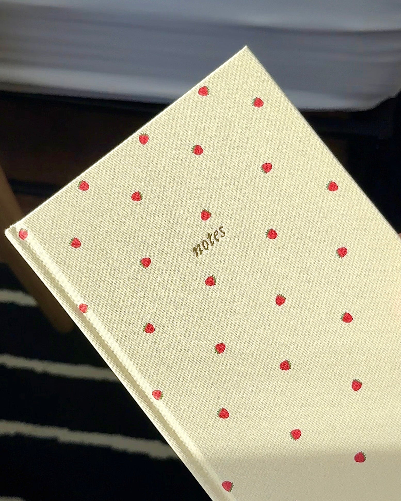 Cream linen A5 notebook with a delicate strawberry pattern and gold notes lettering on the cover.