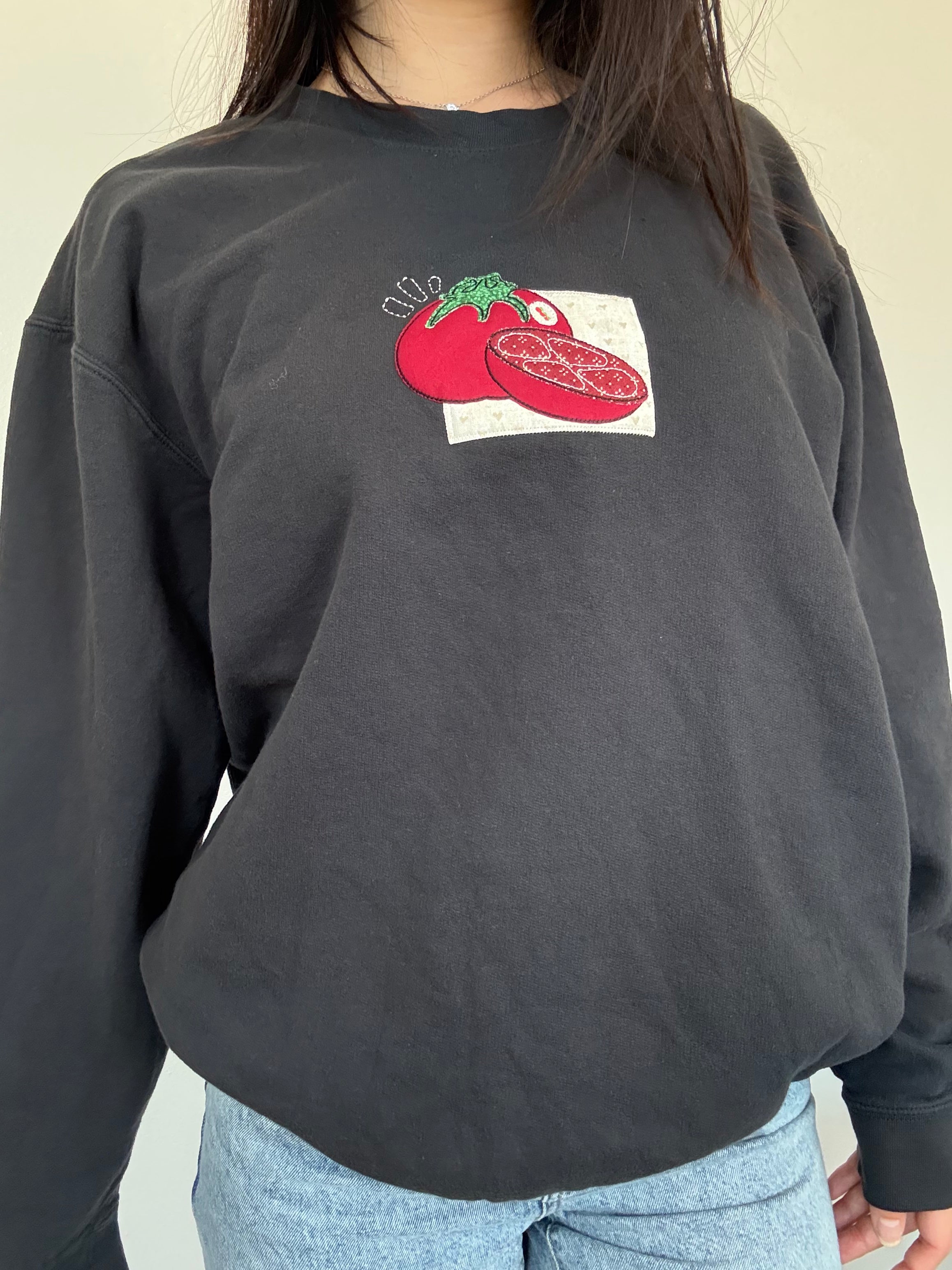 Black vintage-style sweatshirt with red tomato patchwork embroidery centered on the chest, lightweight foodie crewneck with handmade stitched design.