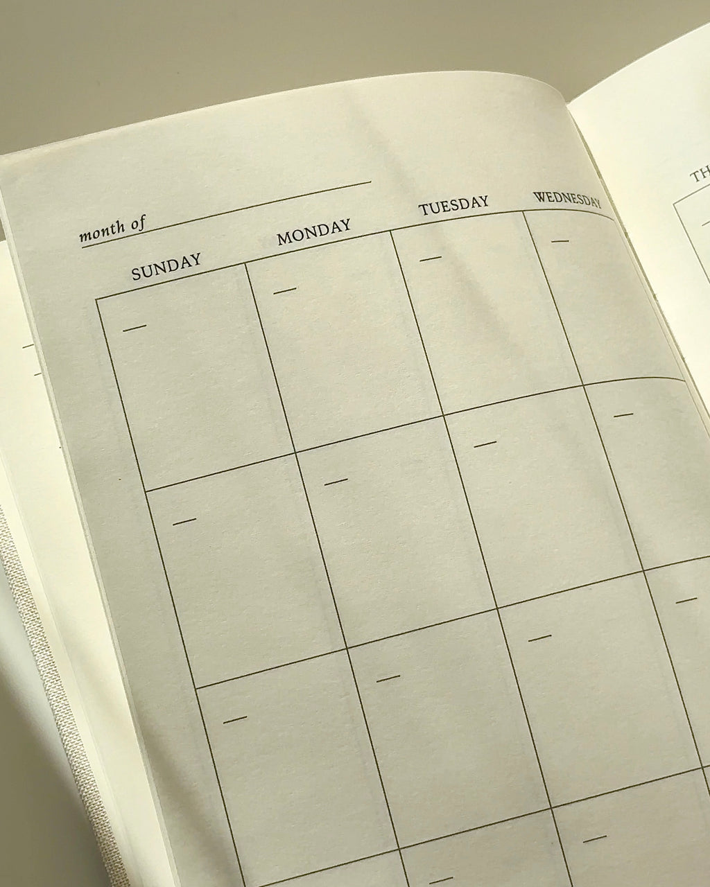 Minimal undated monthly calendar spread inside a daily planner, clean layout for flexible planning without fixed dates.