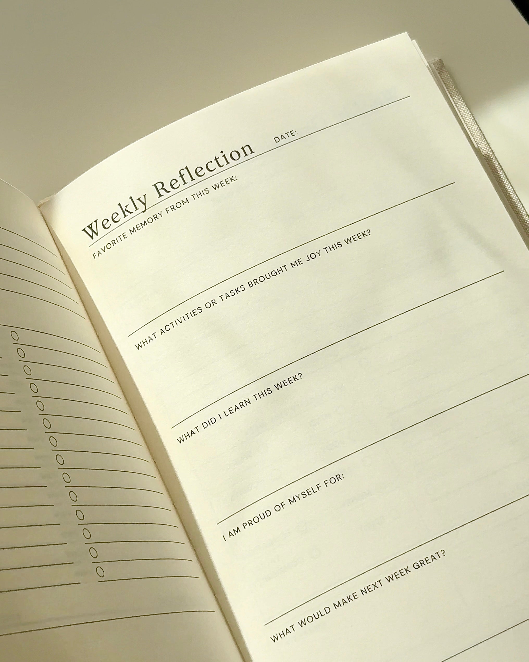 Weekly reflection pages inside an undated daily planner with prompts for gratitude, learning, and mindful self-reflection.