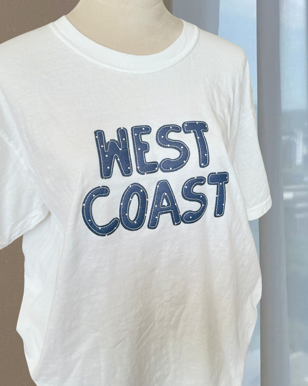 close up of west coast graphic text on white oversized t shirt soft cotton casual coastal style